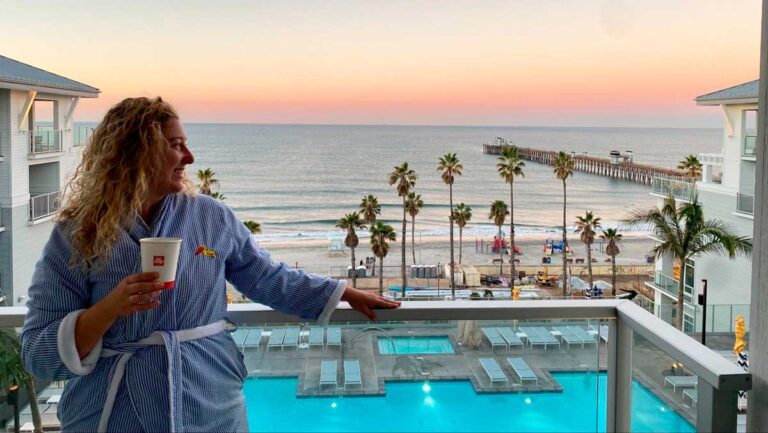 The author Jess in Seabird Resort's balcony with the ocean view at sunset