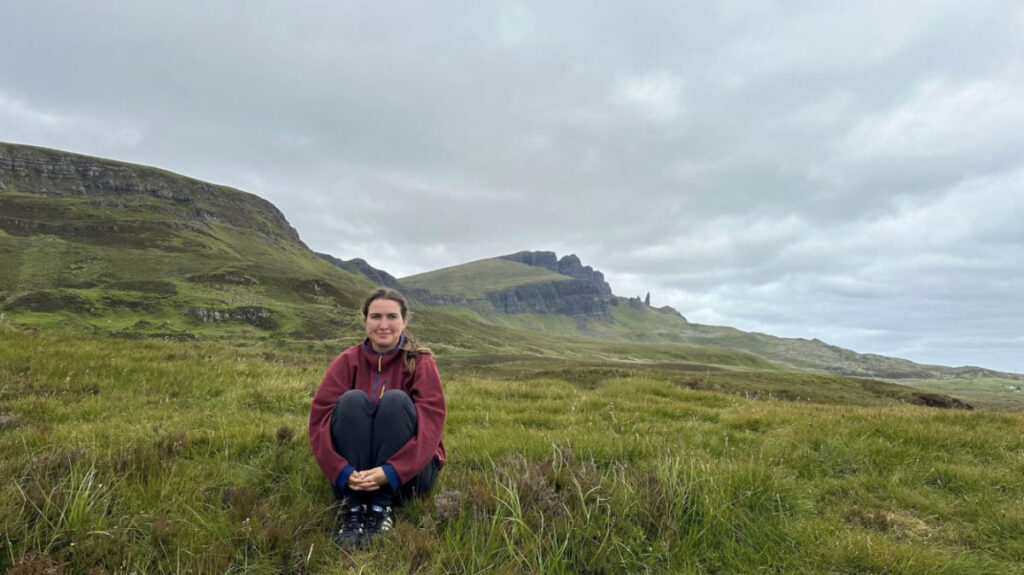 Author Laura sitting in a field in the Isle of Skye