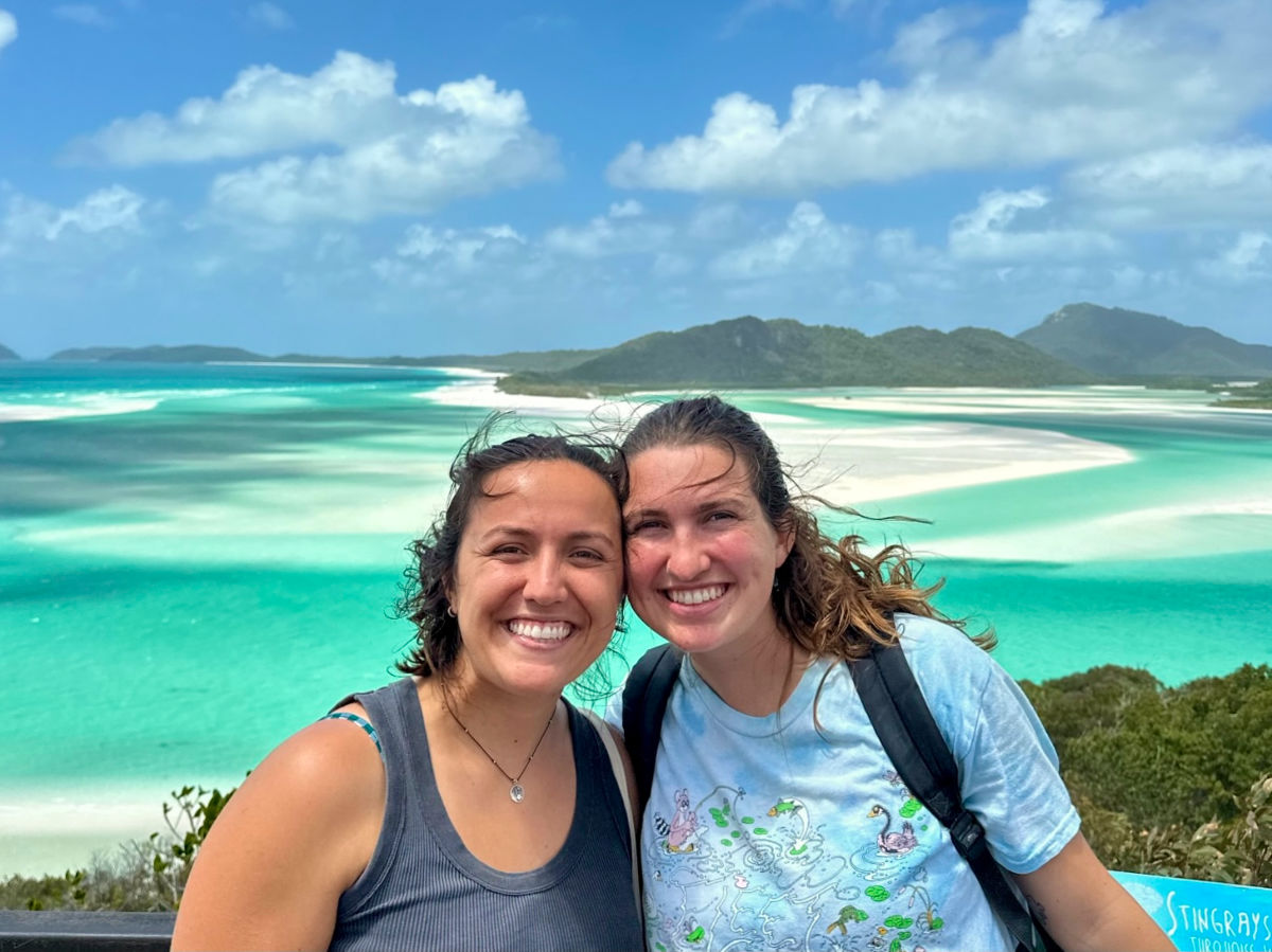 Author Laura and her partner smiling brightly at Whitehaven Beach