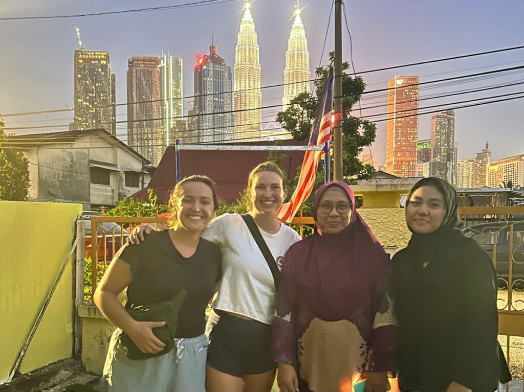 Author Laura with their tour guides and the Petronas Twin Tower in the background