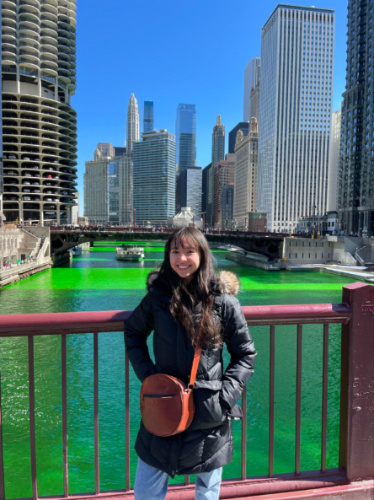 Author Lea Rose on a bridge above the green colored Chicago river