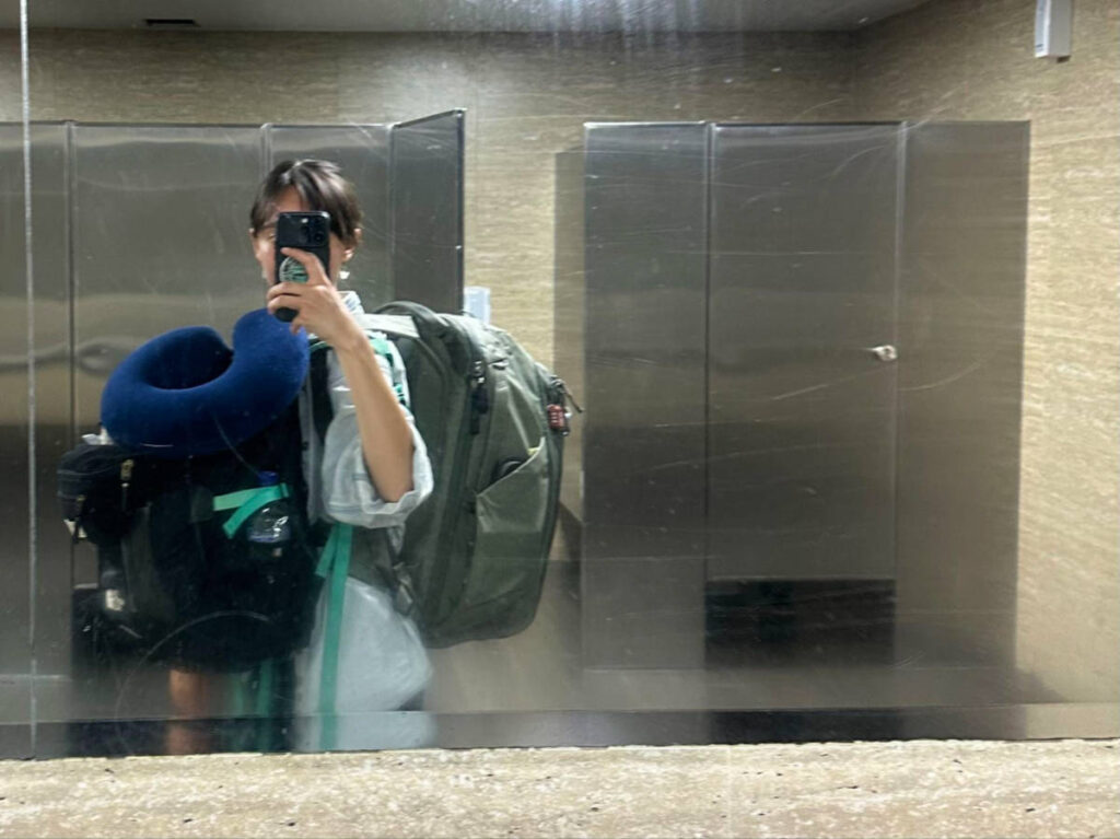 Author Lea Rose doing a mirror selfie while carrying her bags