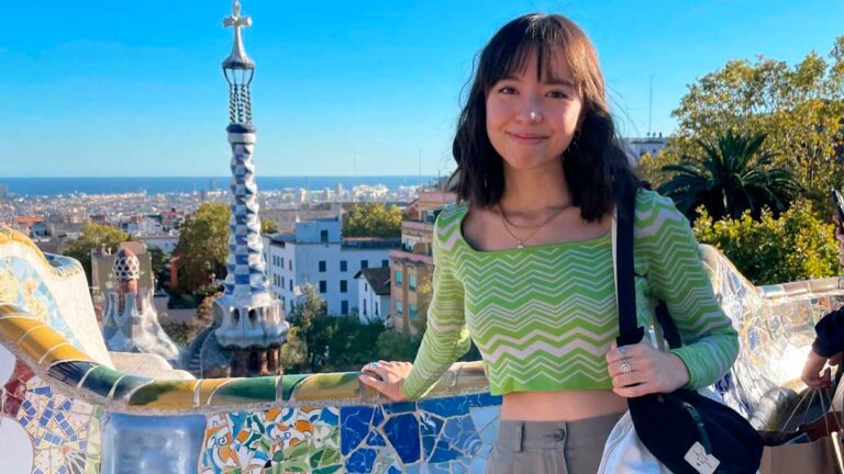Author Lea Rose posing for a photo at Park Güell on a sunny day