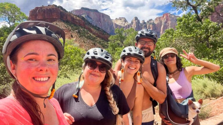 The author McKenna Mobley with her friends, posing for a photo while wearing their biking helmets at the Zion National Park