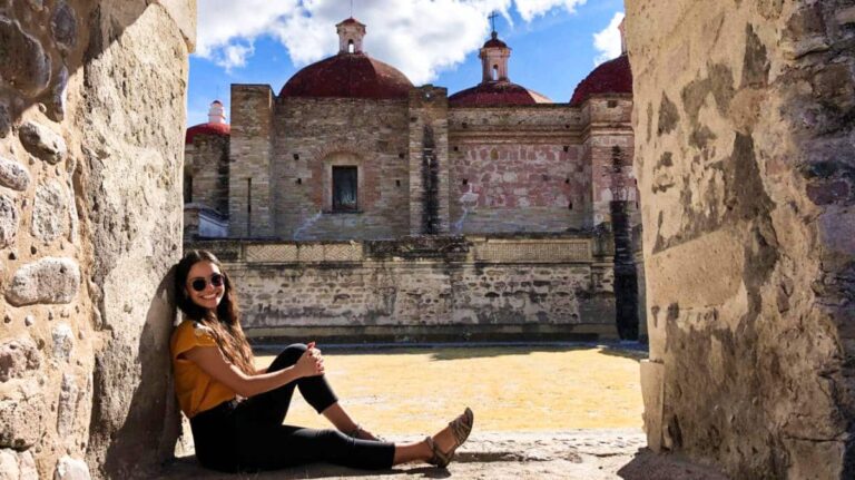 The author McKenna Mobley sitting in the middle of a passage with the historical site in the background