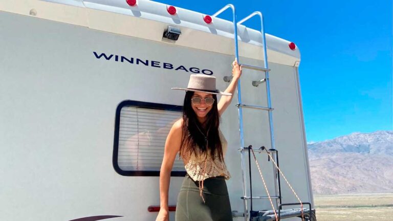 McKenna hanging from an RV and smiling for a photo