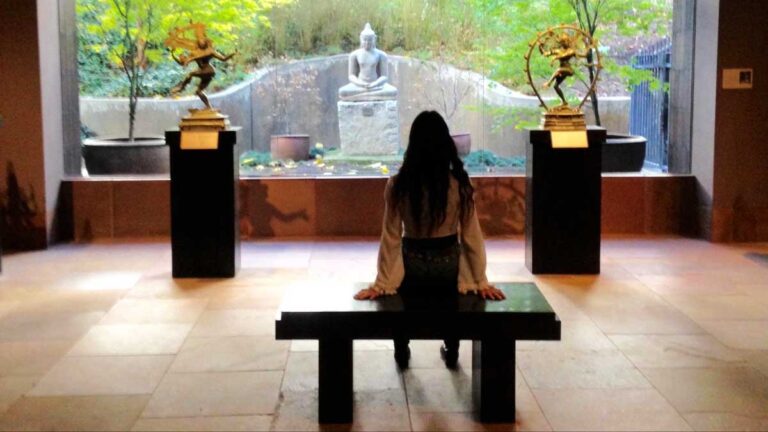 The author McKenna Mobley looking at a big window showing the buddha in Norton Simon Museum