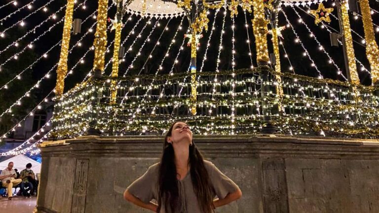The author McKenna Mobley posing in front of a gazebo with stringed lights in Oaxaca during the dry season