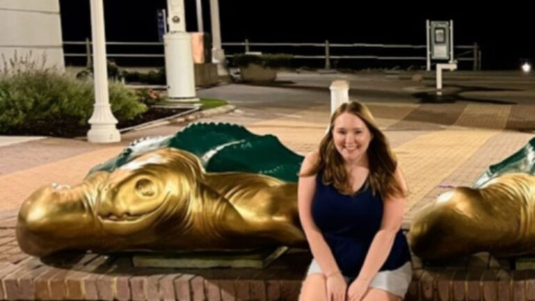 Author Michelle sitting near the Turtle Sculptures along the Boardwalk