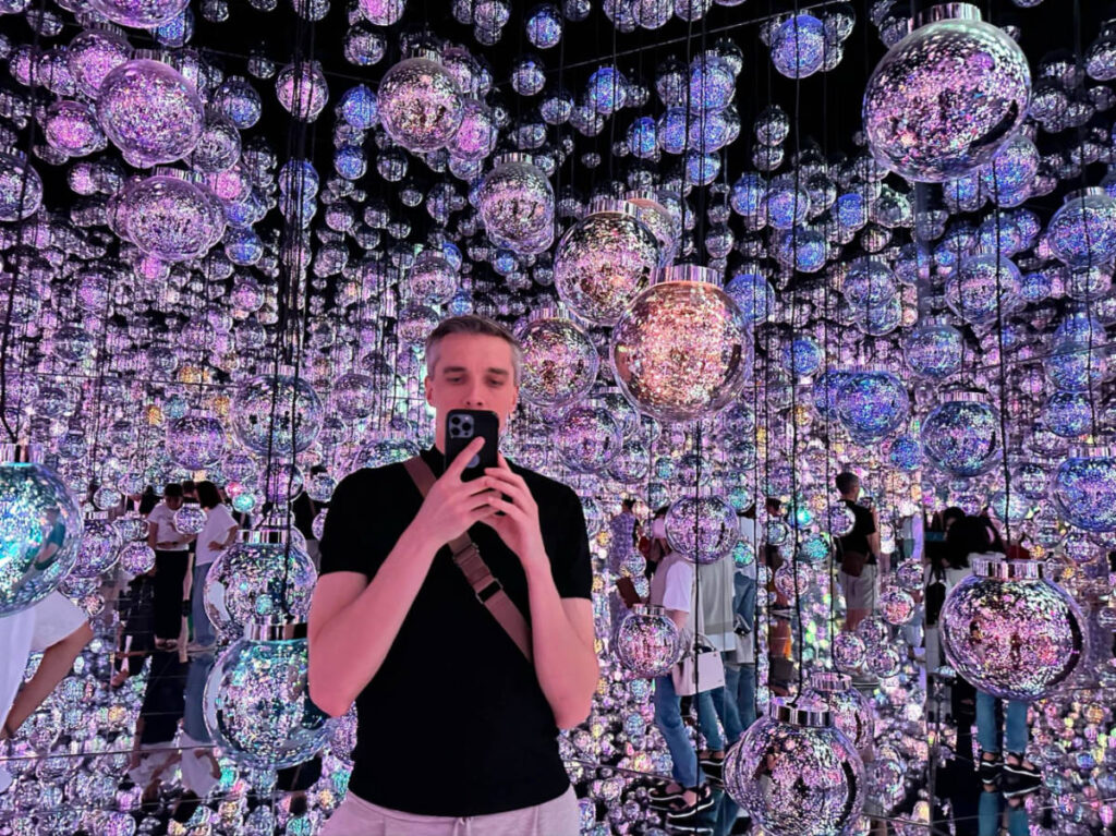 Author Nate taking a mirror selfie at the teamlab Borderless digital art room