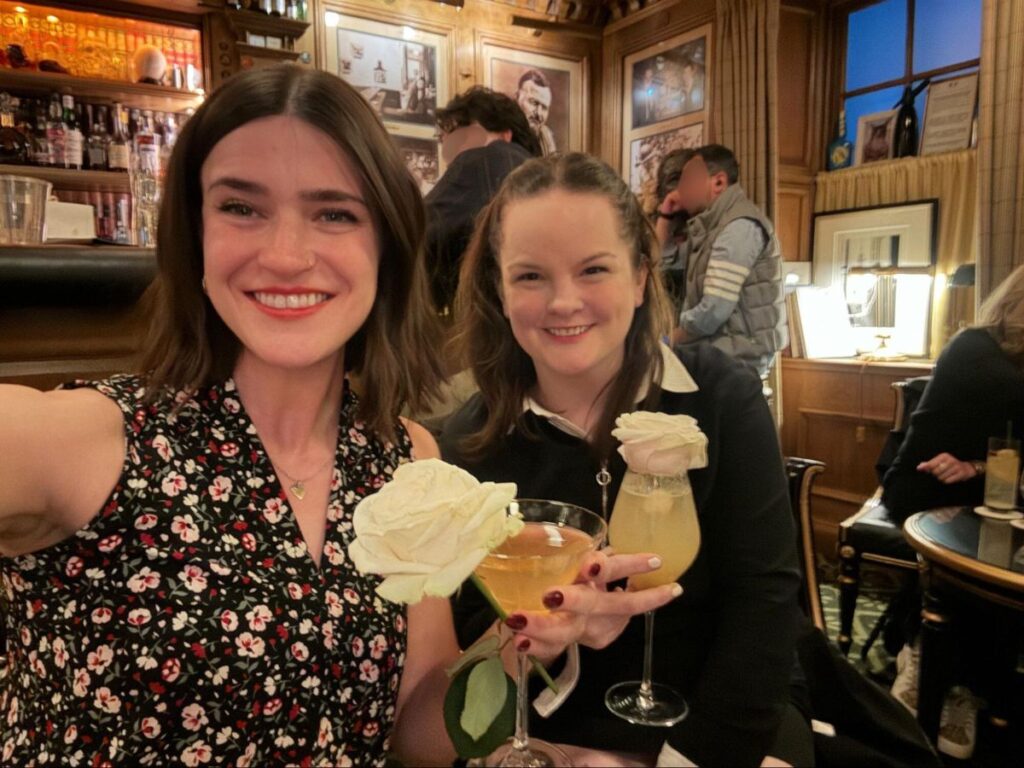 Author Rachel and Betty holding their cocktails with white roses at Bar Hemingway