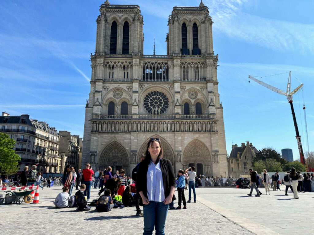 Author Rachel standing in front of the crowded Notre Dame Cathedral