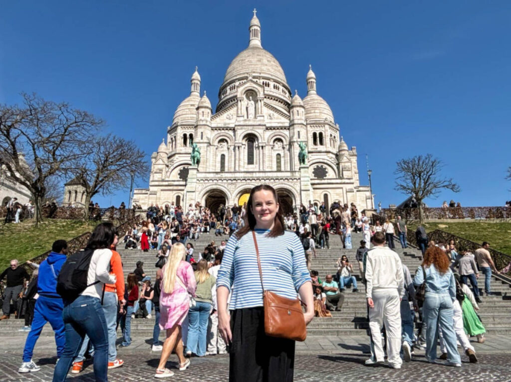 Author Rachel in front of the crowded stairs to Basilica Sacre Coeur