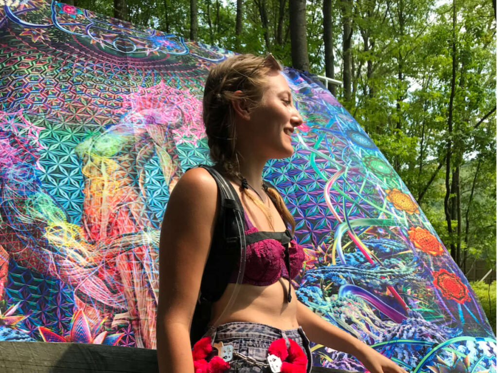 Side view of Author Sky wearing a water backpack at Camp Bisco