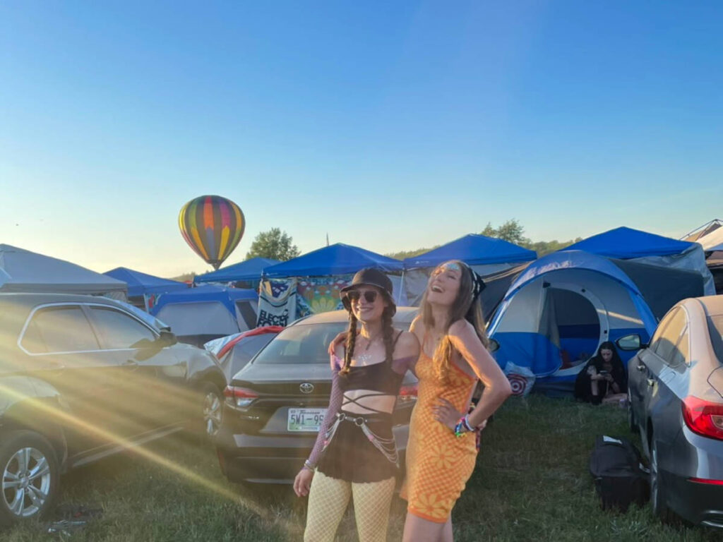 Author Sky and her friend smiling brightly at Electric Forest camping and parking site