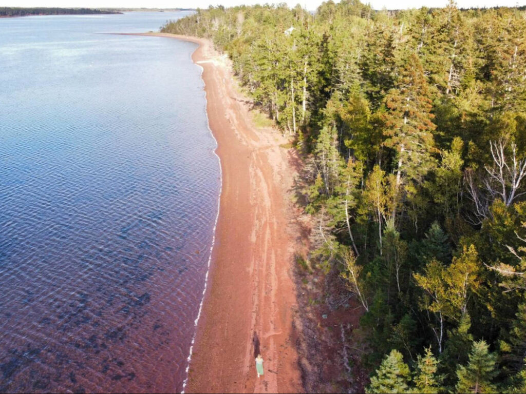 Drone shot view of Taylor walking along the shores of Kings Castle Provincial Park