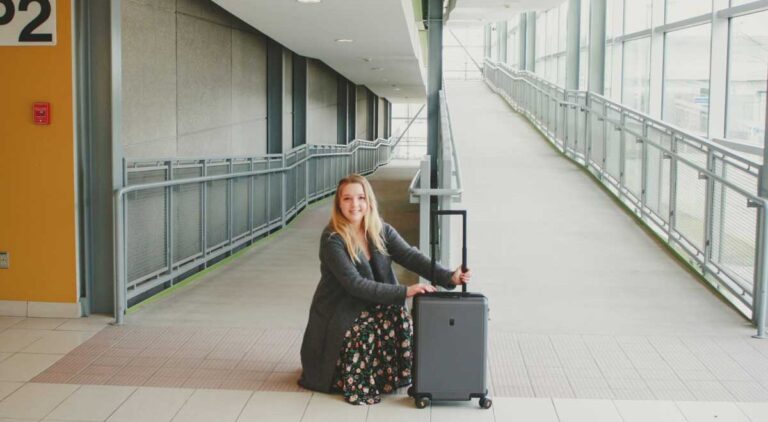 The author holding her Carry On Luggage in an airport