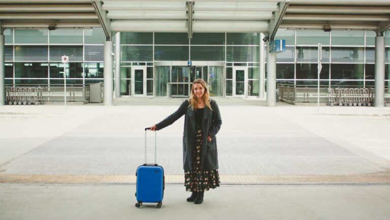 Author Taylor holding a suitcase at the airport