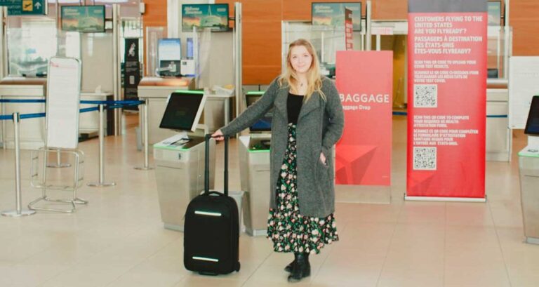 Author Taylor standing with her suitcase at the airport