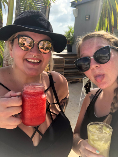 Author Taylor and her friend enjoying their drinks at a rooftop pool