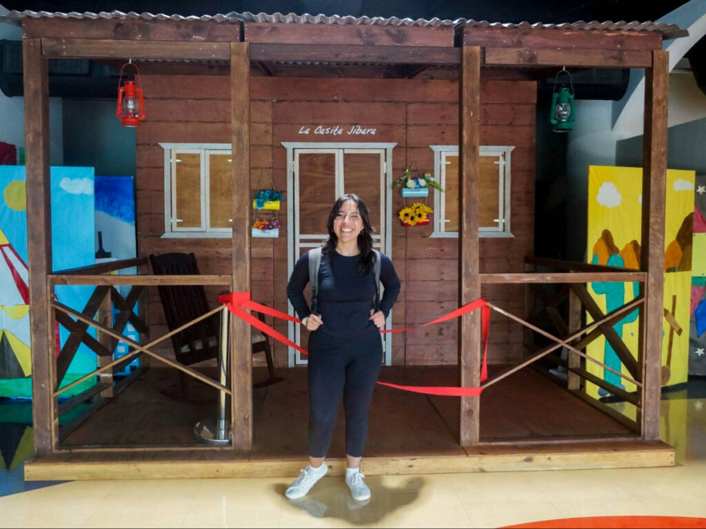 Author Vanessa in front of a traditional jibaro house within the museum