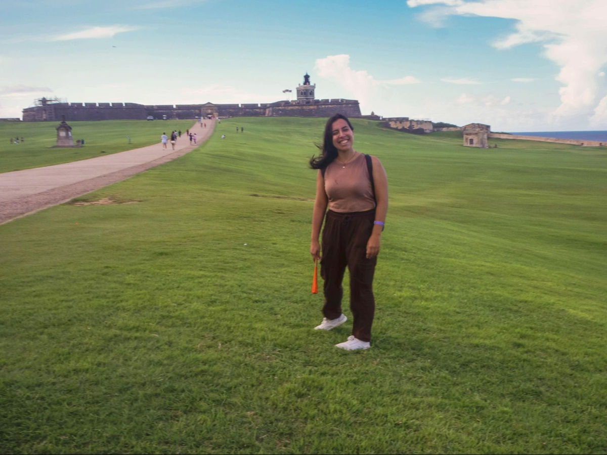 Author Vanessa standing at the grass area at Castillo San Felipe del Morro