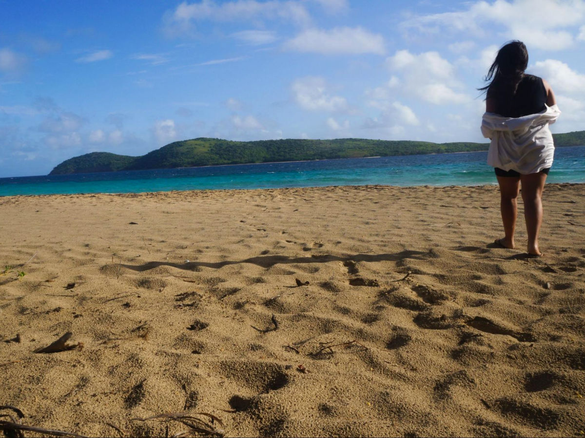 Author Vanessa standing on the sandy shore of Zoni Beach