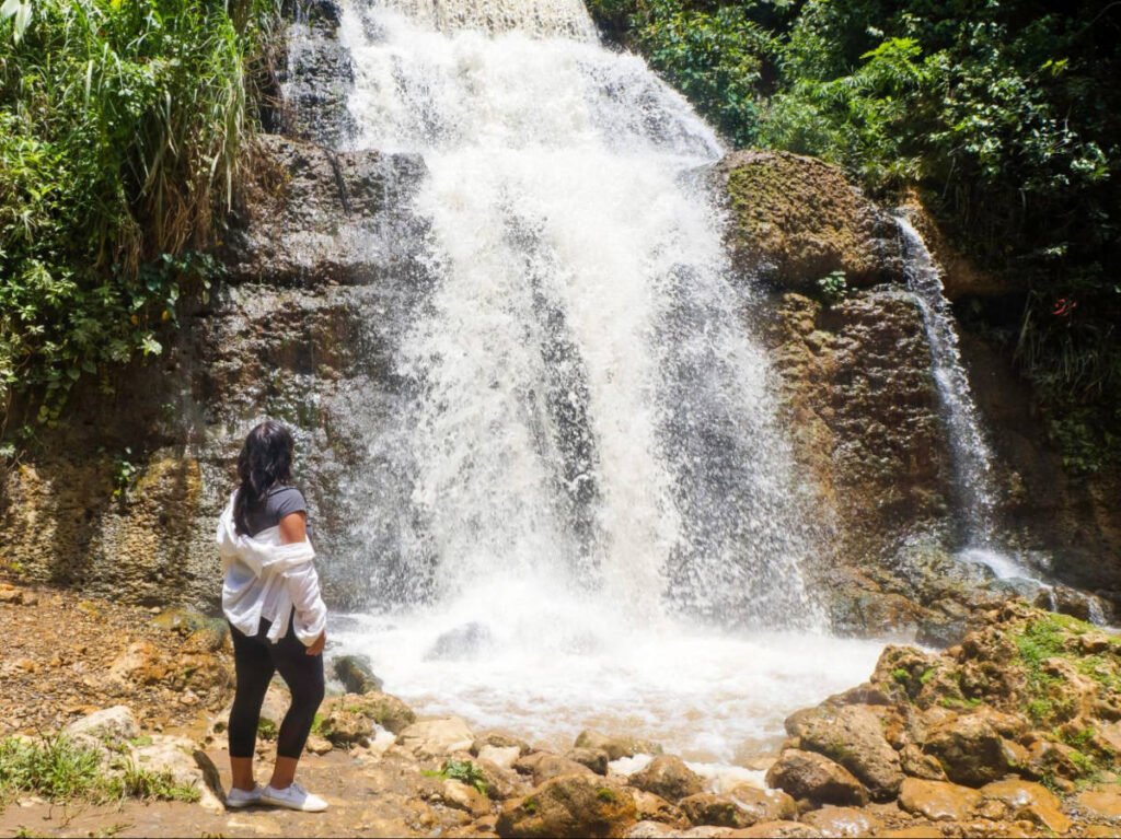 Author Vanessa stands in front of the waterfall of Charco Hondo