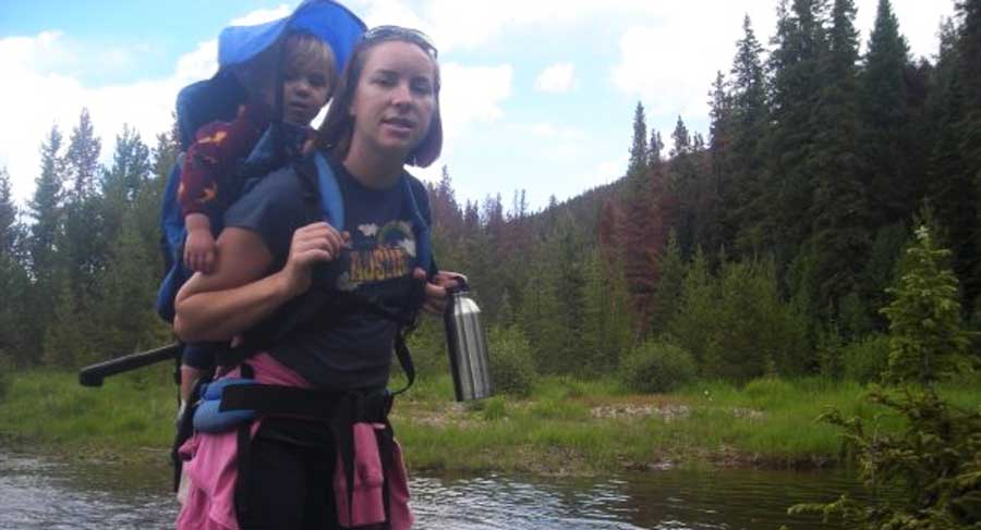 The author carrying her kid on her back during their hike