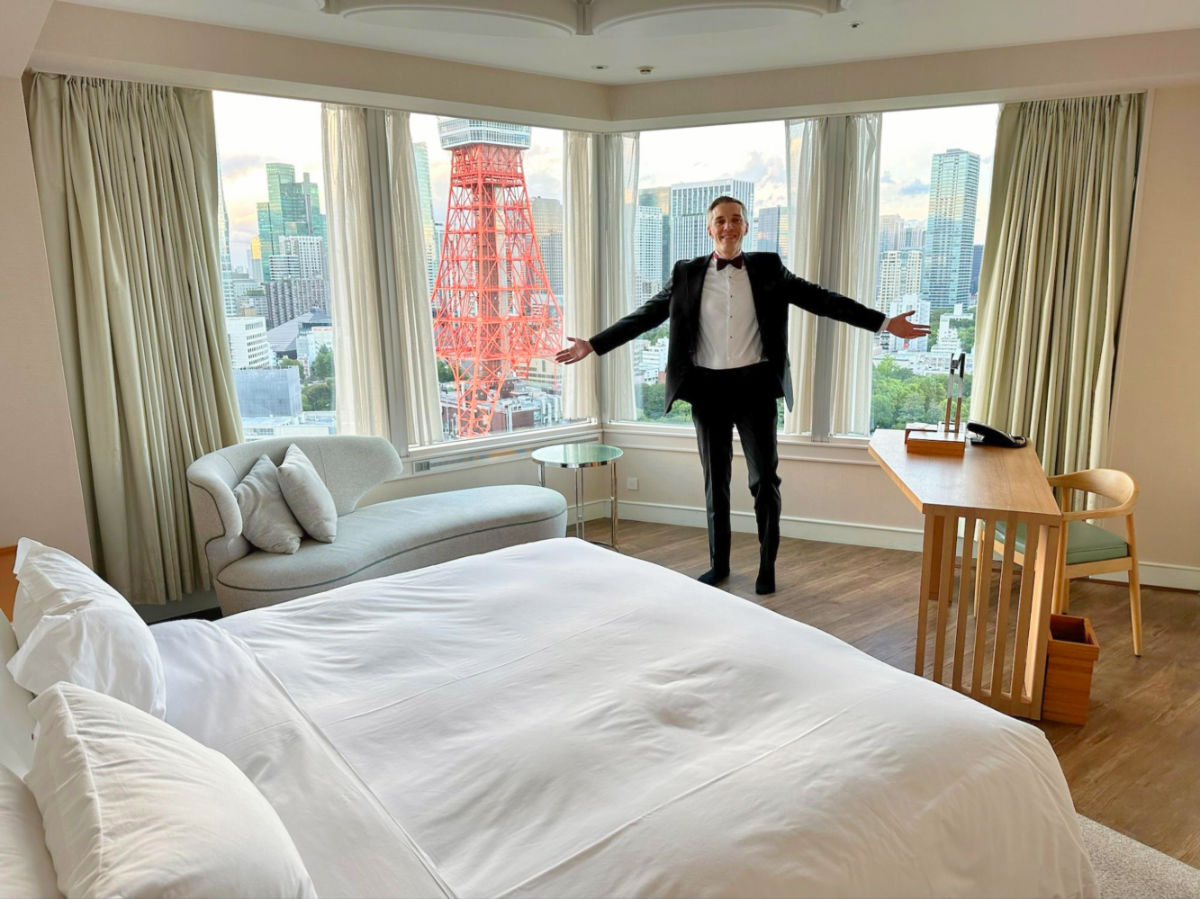 Author Nate in formal wear showing the tower view room of Prince Park Tower Tokyo