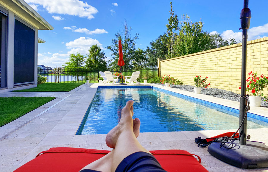 View of a backyard swimming pool with a clear blue sky