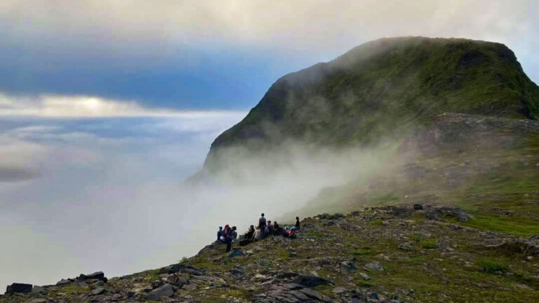 A group of hikers enjoying at the cliff on a misty day in Kodiak