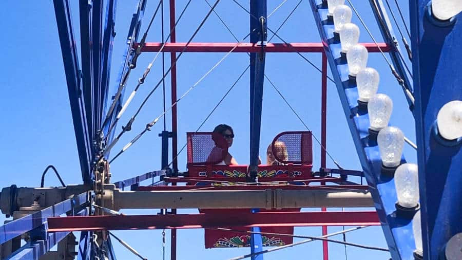 View of a mother and daughter riding the Balboa Fun Zone Ferris wheel