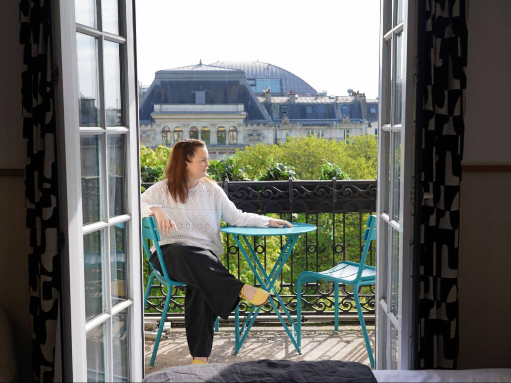 The author Rachel Kapelke-Dale sitting on a balcony at Solly Hôtel Paris