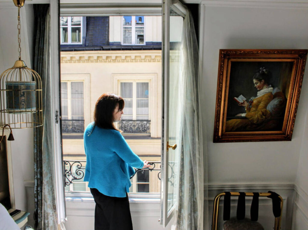 The author Rachel Kapelke-Dale admiring the view on the balcony at the Académie Hôtel