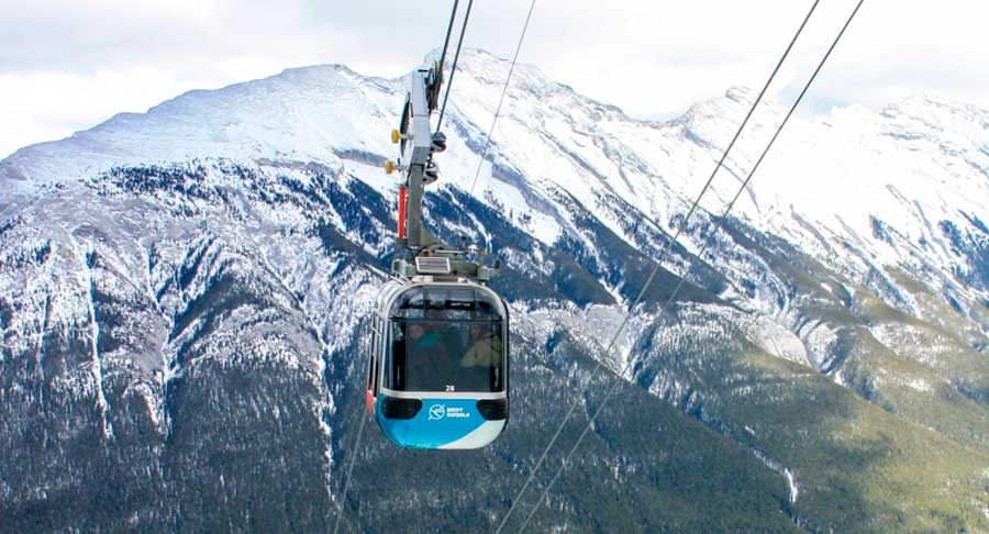View of a Banff gondola with a snowy mountain on the background