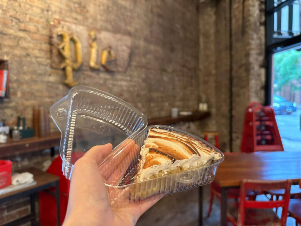 A hand holding a key lime pie from Bang Bang Pie & Biscuits