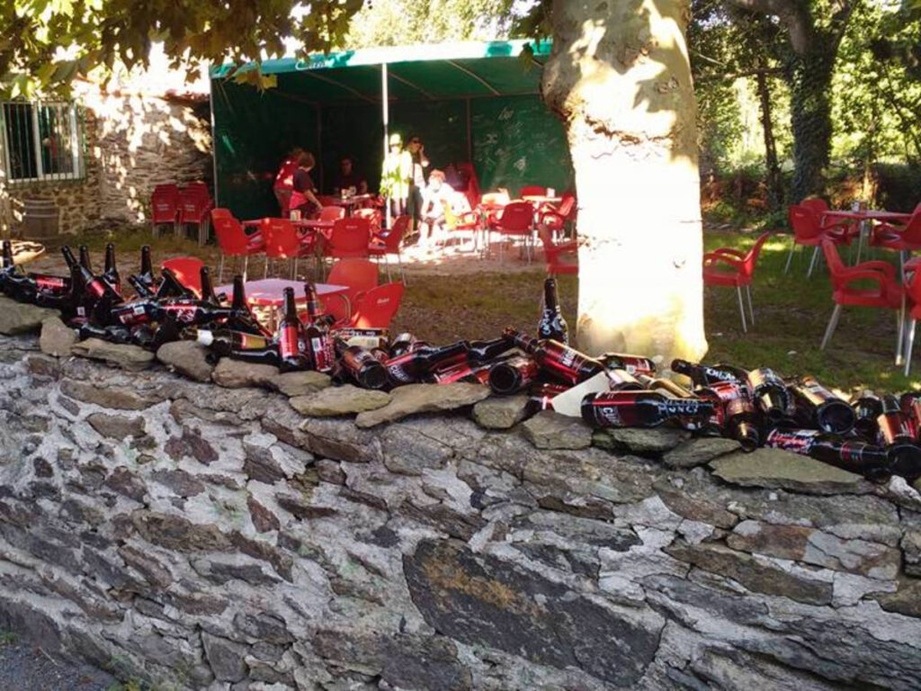 Empty beer bottles outside a quirky bar at Camino Francés