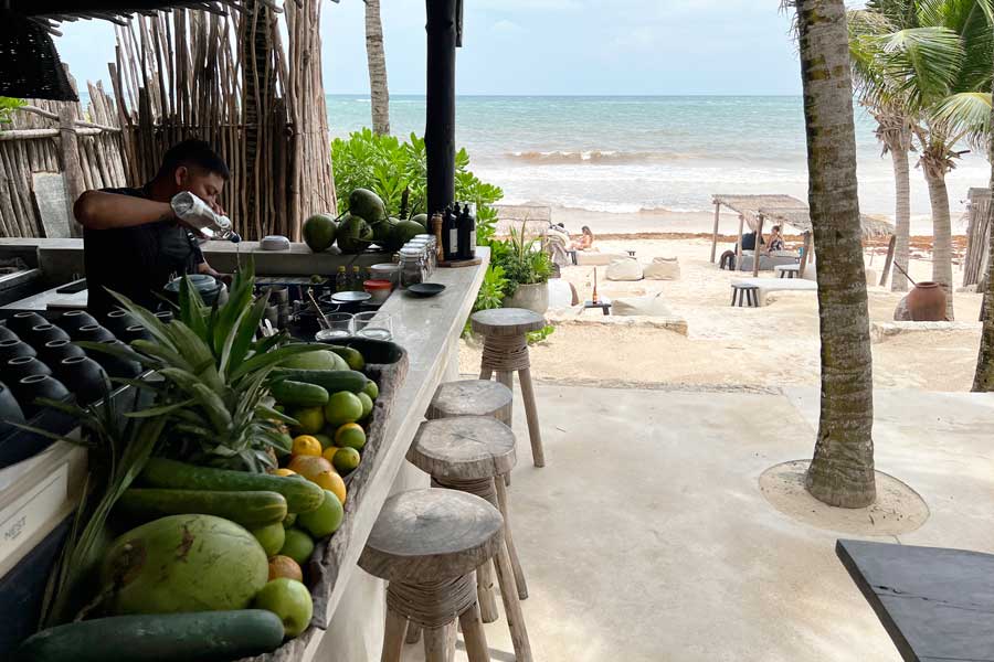 A bar counter with a beach view in NEST Tulum