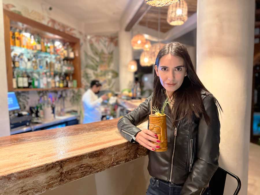 Clara holding a tiki cocktails in Nerea Tulum