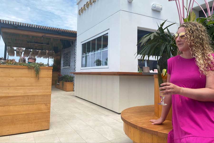 The author holding her drinks on the rooftop of The Brick Hotel