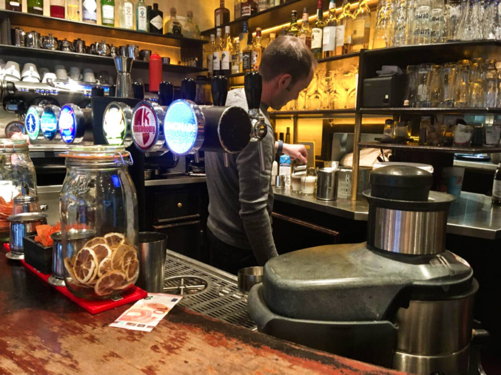 A bartender preparing a coffee at a cafe in France