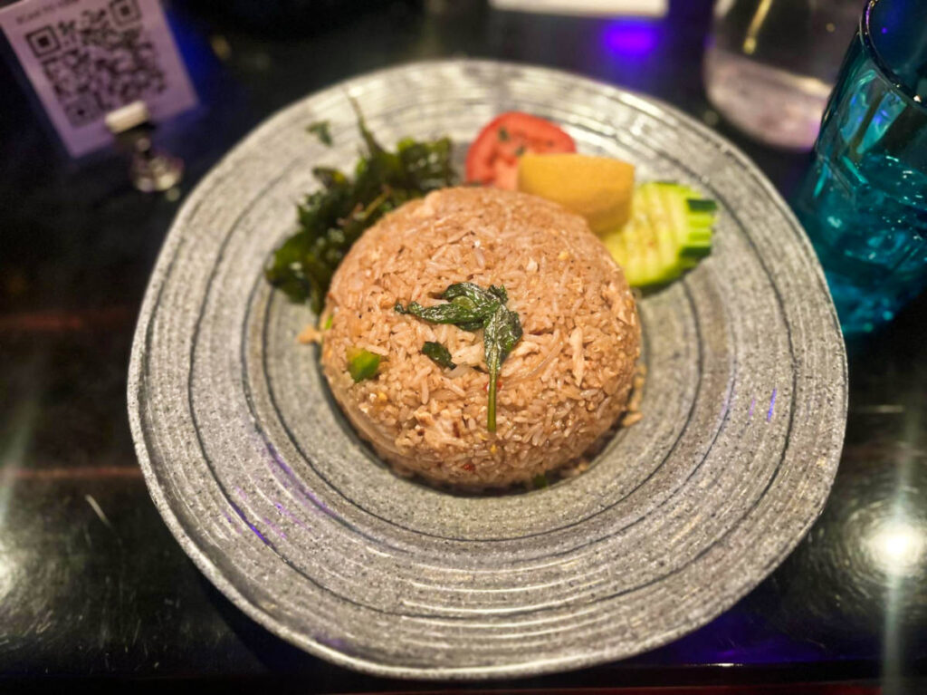 A plate of basil fried rice with grilled chicken from V{IV}