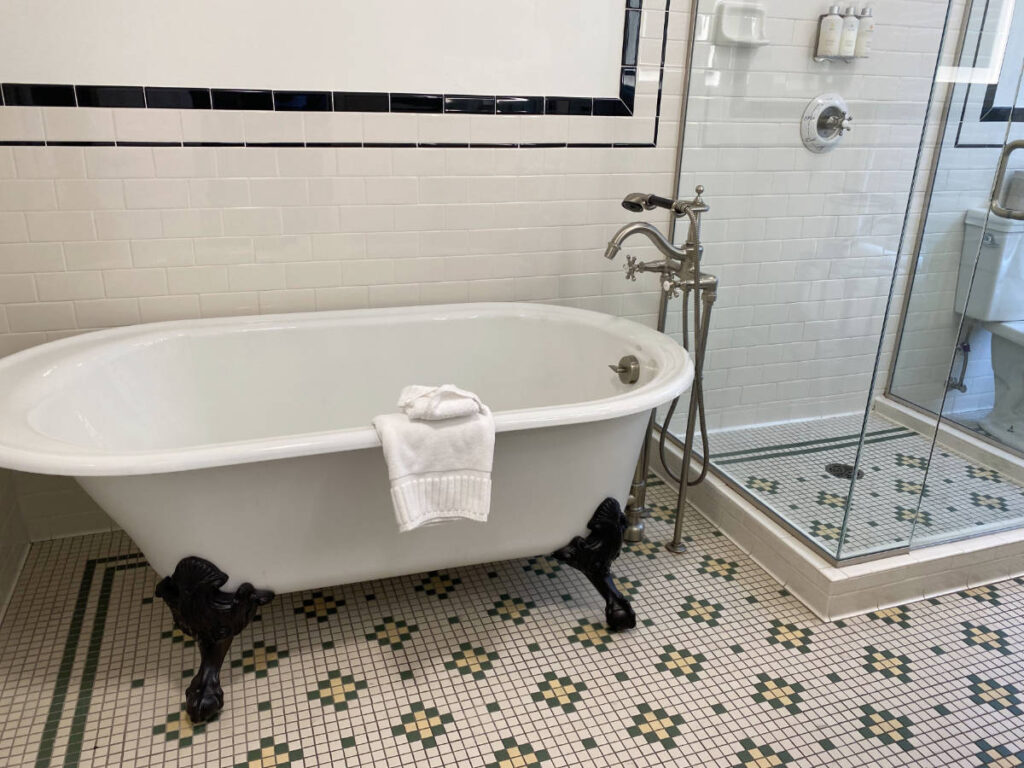 A bathtub and shower inside the bathroom in The Oxford Denver Hotel