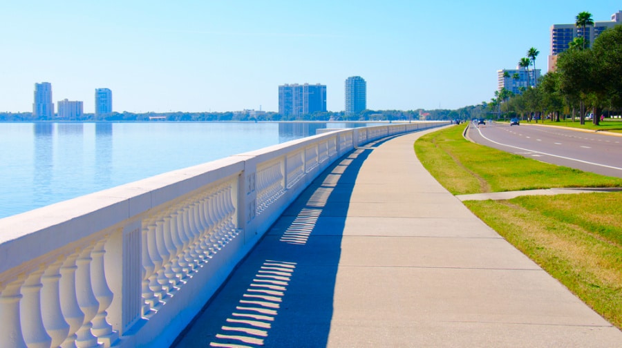 Long sidewalk of Bayshore Boulevard with a scenic view of the ocean and the city of Tampa