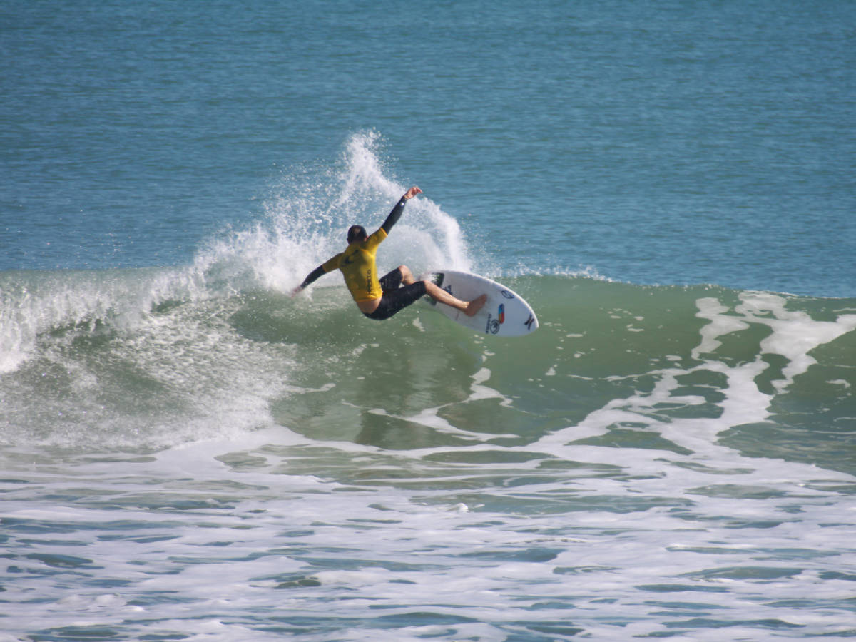 A man surfing on the huge beach wave