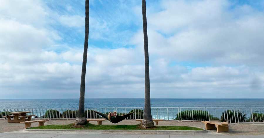 The author with her dog on a hammock with a beach on the background