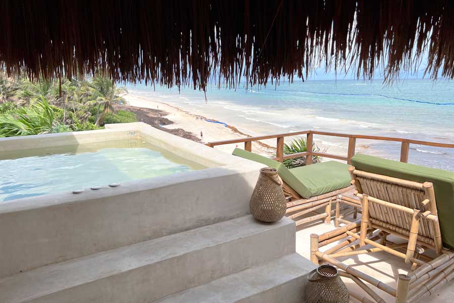 A jacuzzi on a balcony with a view of the beach in Mezzanine