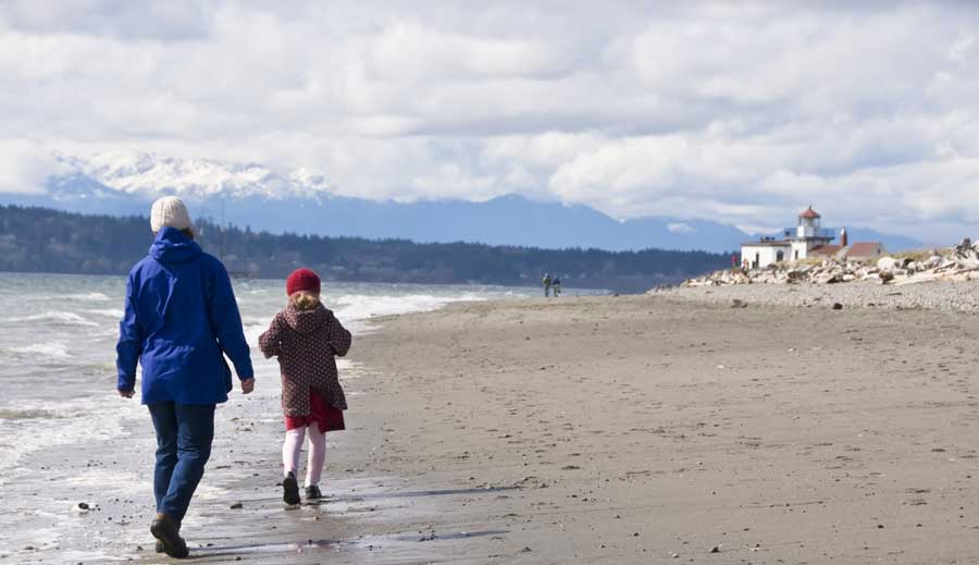 A mother with her child walking by the beach in Magnolia