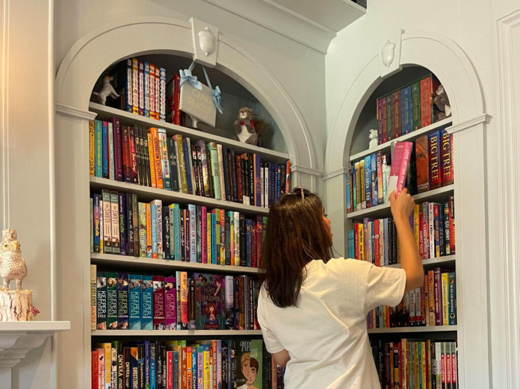 Author Claudicet Pena skimming through books in the Beacon Hill Books & Cafe